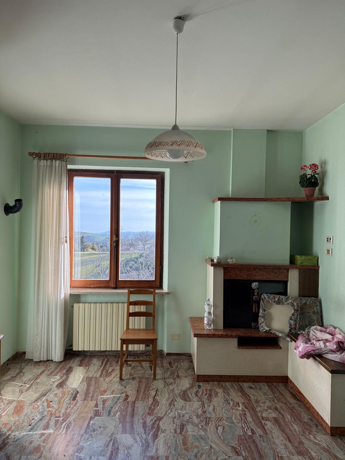 Sala comune con camino e vista sulle colline